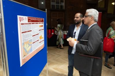 Two delegates review academic poster